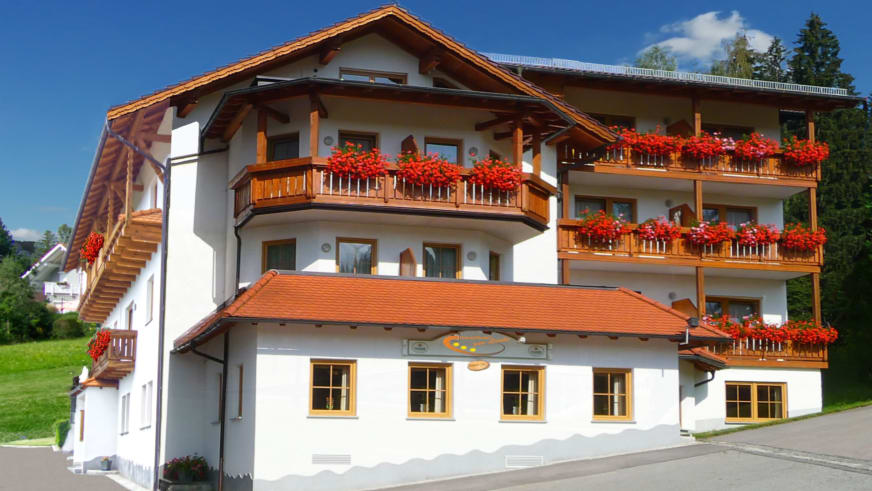 Außenansicht des Hotel-Garni zur Linde in Lohberg mit traditioneller Alpenfassade und Holzbalkonen.