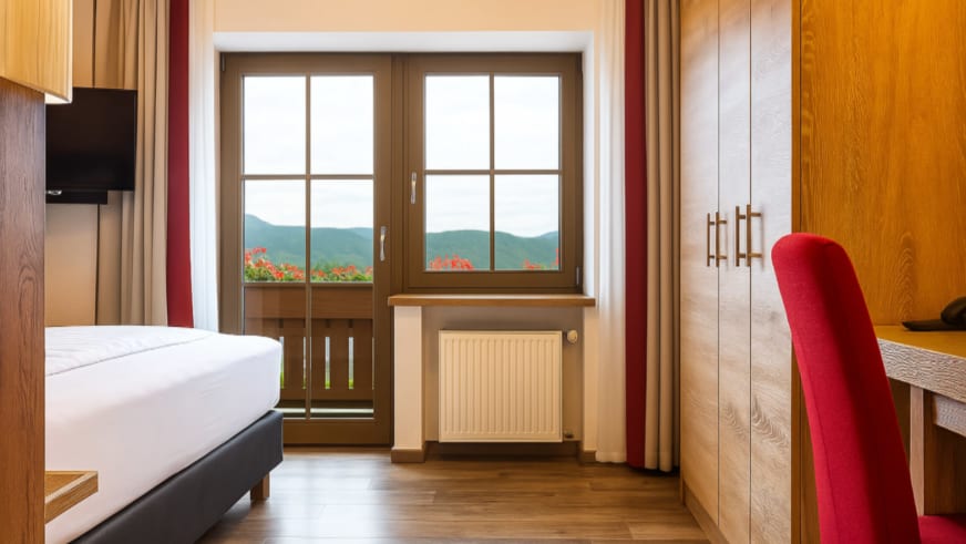 Einzelzimmer im Hotel-Garni zur Linde mit Holzausstattung und Blick auf die Berge des Bayerischen Waldes.