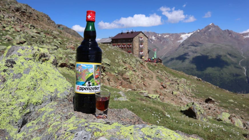 Appenzeller Flasche mit Glas im Vordergrund und Blick auf die Breslauer Hütte im alpinen Bergpanorama der Ötztaler Alpen