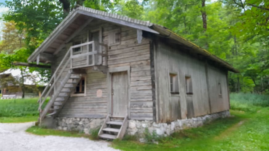 Traditionelles Holzgebäude des Ostwandlager umgeben von Laubwald am Königssee.