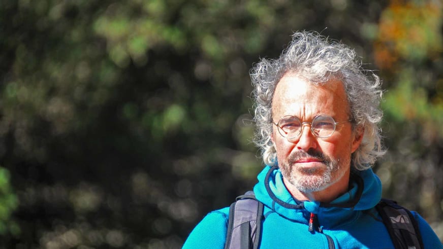 Portrait von Bergwanderführer Nacho Carreras Codina in türkis-blauer Fleecejacke vor herbstlicher Vegetation.