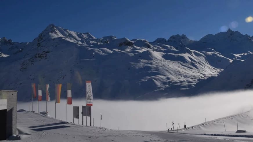 Winteraufnahme vom Berggasthof Piz Buin auf der Bieler Höhe über einer geschlossenen Wolkendecke im Tal.