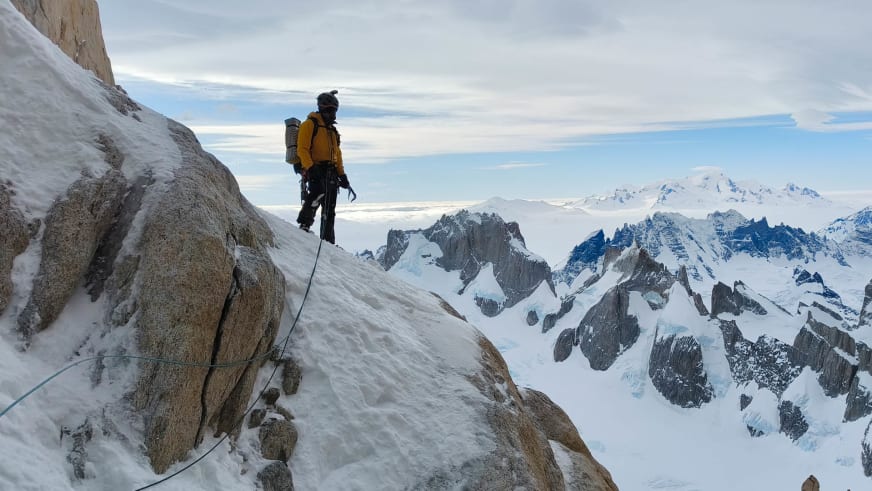 Mit Pickel und blauem Seil steht Bergführer Alexander Berger auf steilem, verschneitem Hang im Hochgebirge.