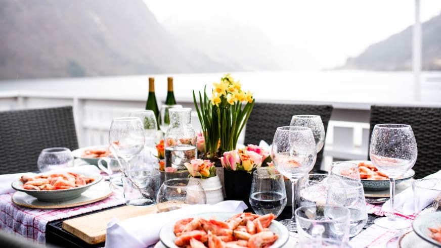 Gedeckter Tisch auf der Terrasse des Fjærland Fjordstove Hotells mit direktem Blick auf den Sognefjord.