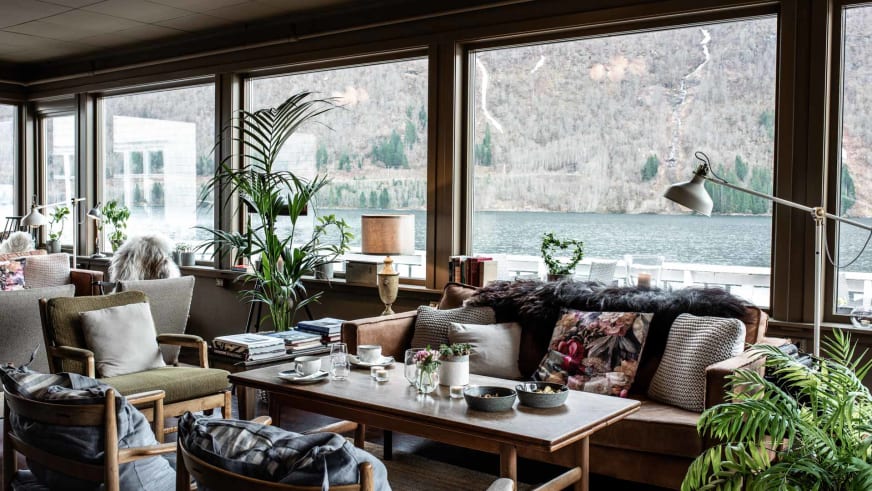 Moderne Lounge im Fjærland Fjordstove Hotell mit großer Fensterfront und Blick auf den Sognefjord.