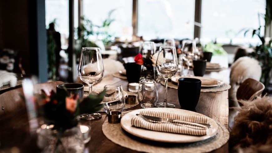Elegant gedeckter Tisch im Restaurant des Fjærland Fjordstove Hotells mit warmer Beleuchtung.