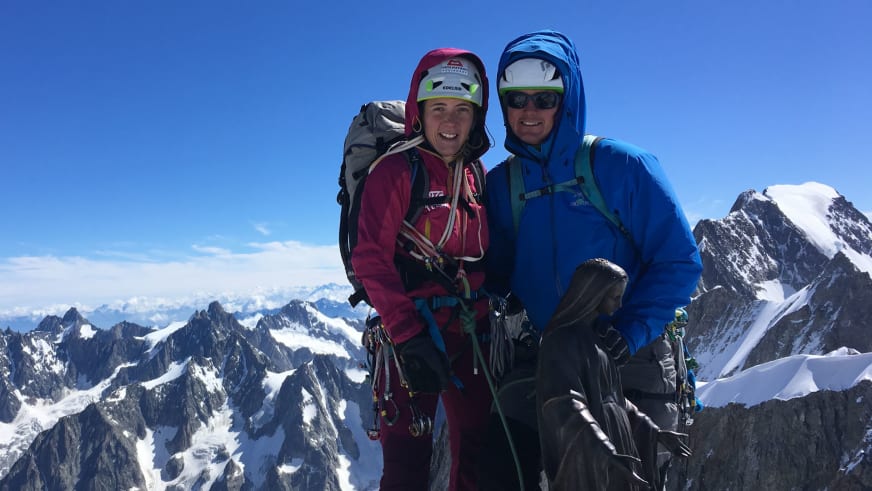 Zwei Personen stehen auf Felsgrat, rechts Bergwanderführer Patrick Hindelang in blauer Jacke mit Helm und Sonnenbrille.
