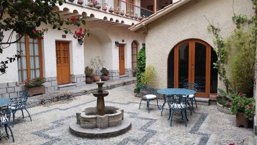 Gepflasterter Innenhof mit steinerner Brunnen im Hotel Rosario La Paz im Kolonialstil.