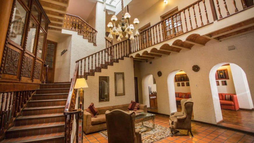 Mehrstöckige Hotellobby mit geschwungener Holztreppe im Hotel Rosario La Paz im Kolonialstil.