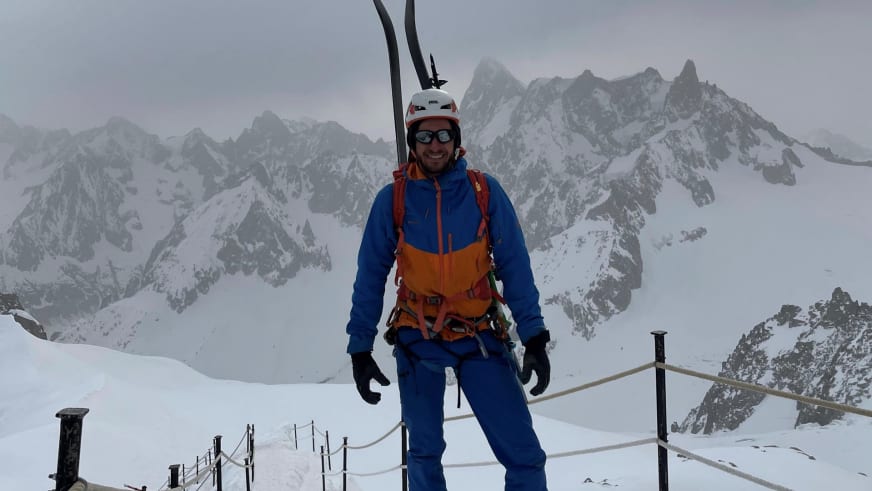 Auf einer Aussichtsplattform in Chamonix steht Bergführer Christoph Blumrich mit Skiern und Klettergurt.