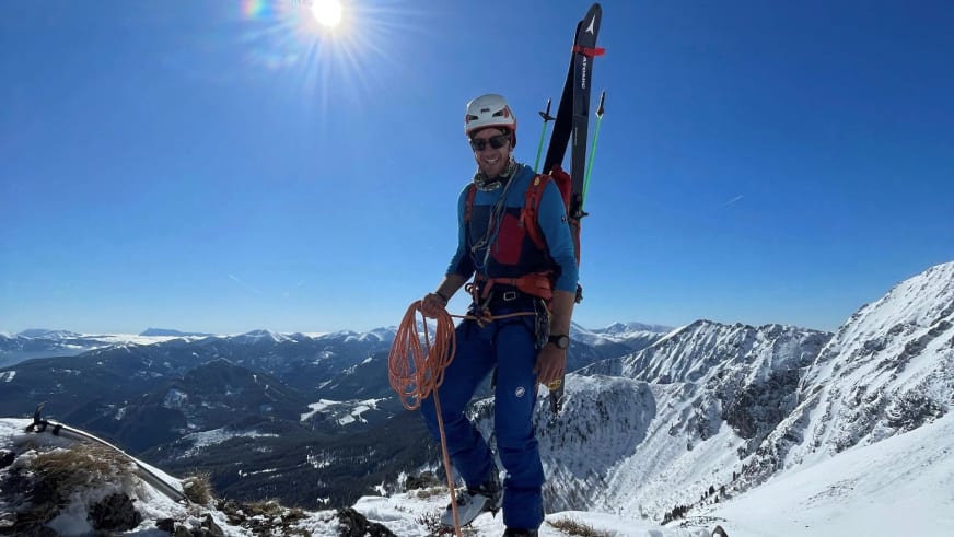 Bergführer Christoph Blumrich steht beim Winterbergsteigen auf schneebedecktem Gipfel mit rotem Seil und Skiern.