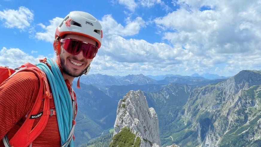 Bergführer Christoph Blumrich macht ein Selfie am Hochschwab-Gipfel mit weißem Helm und türkisem Kletterseil.
