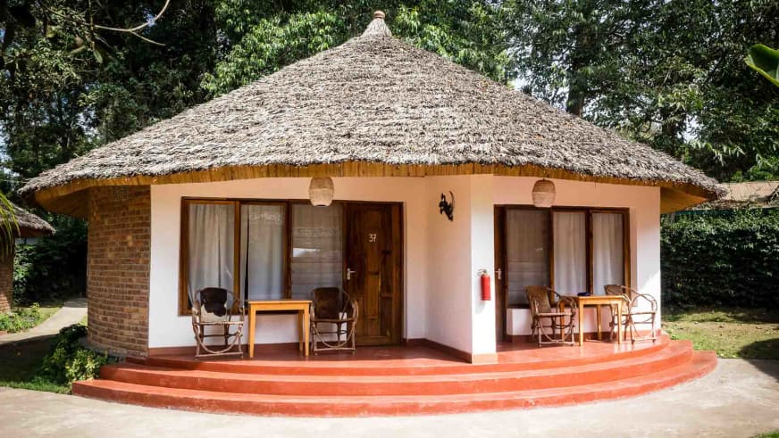Rundbau mit Strohdach und überdachter Veranda in der Ilboru Safari Lodge bei Arusha.