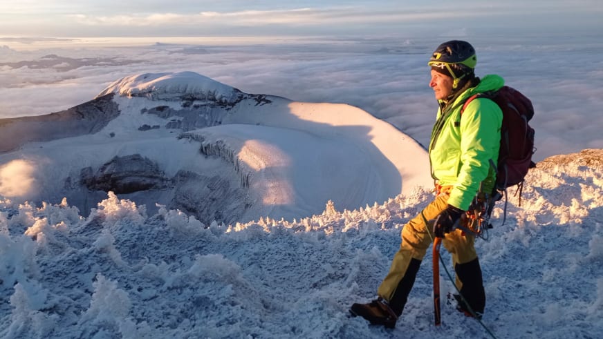 Bei der Winterwanderung steht Bergführer Jürgen Bäumler mit rotem Bergstock über der Wolkendecke im Hochgebirge.