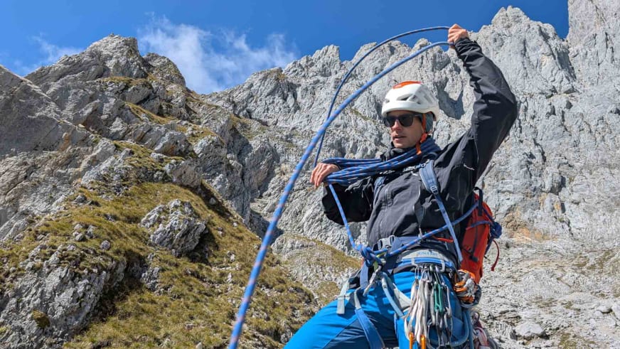 Bergführer Christoph Meysel trägt weißen Helm und blaues Kletterseil vor grauer Kalksteinwand.