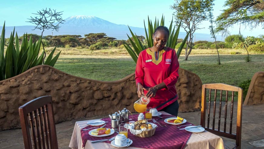 Frühstücksservice auf der Terrasse der Amboseli Sopa Lodge mit Blick auf den schneebedeckten Kilimandscharo.