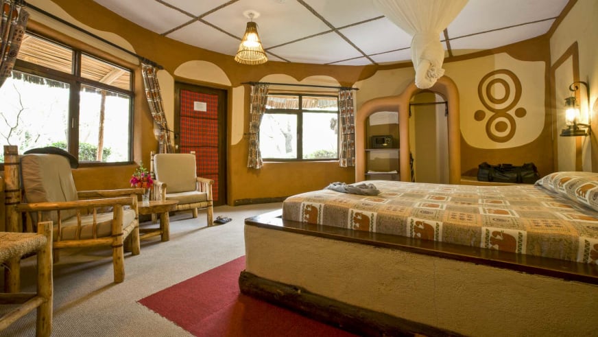 Doppelzimmer der Amboseli Sopa Lodge mit rundem Bett auf Plattform und traditioneller Holzbalken-Decke.