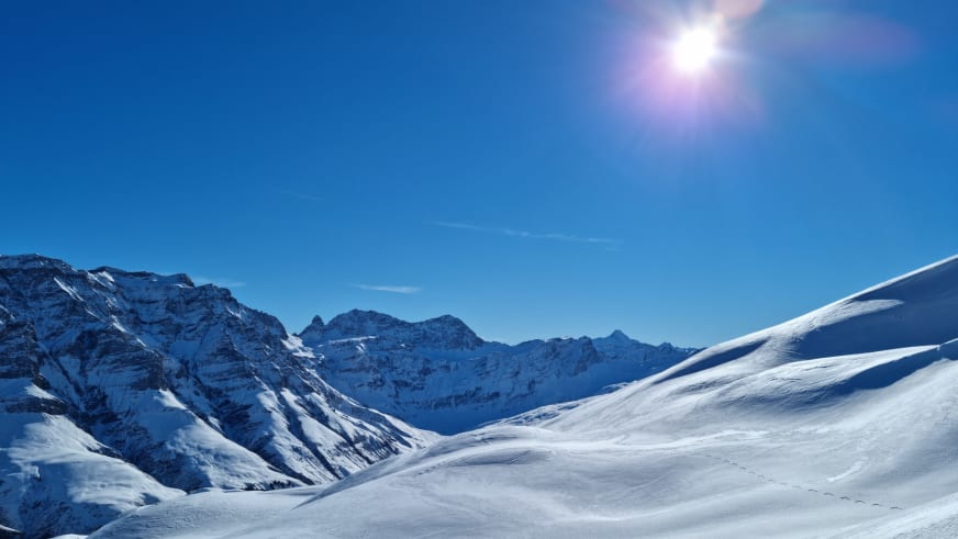 Winterlandschaft der Adula-Alpen rund um das Hotel Camana mit verschneiten Hängen und steilen Felsgipfeln.