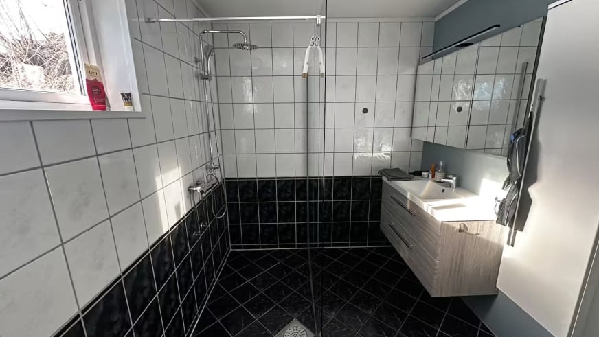 Modernes Badezimmer im Lyngen Blue House mit schwarz-weißen Fliesen und begehbarer Dusche.