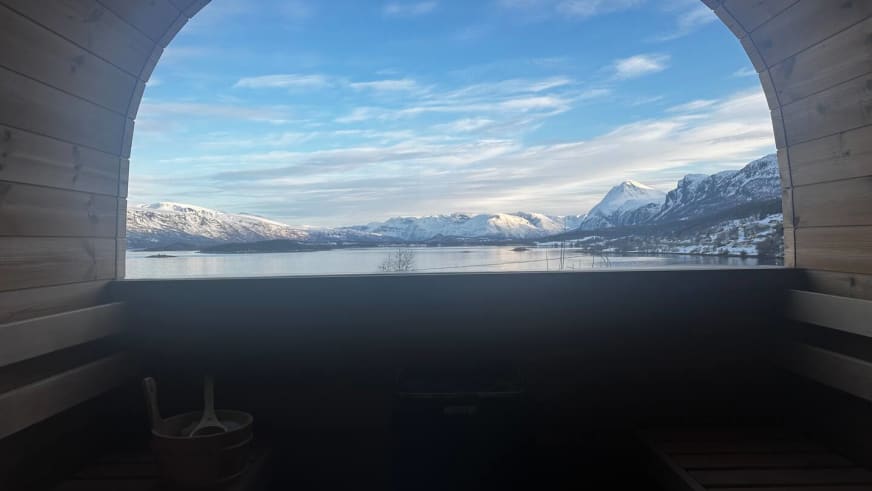 Blick aus der Sauna des Lyngen Blue House durch das Panoramafenster auf den Fjord.