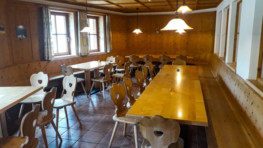 Traditioneller Gastraum der Jamtalhütte mit Kiefernholz-Verkleidung und Holzmöbeln.