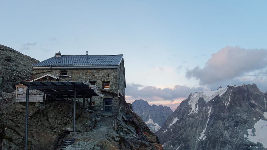 Die Cabane des Vignettes steht auf einem Felsgrat in den Walliser Alpen während der Abenddämmerung.