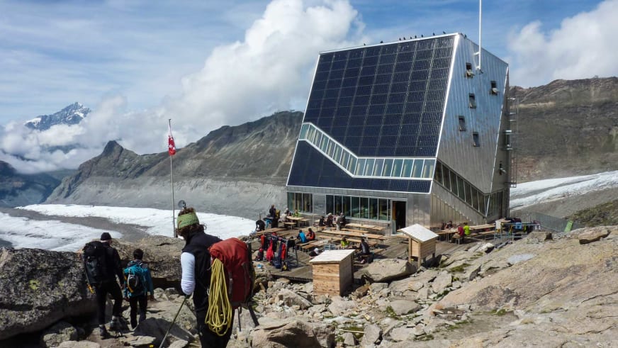Bergsteiger mit Hochtouren-Ausrüstung vor der modernen Monte Rosa Hütte in den Walliser Alpen.