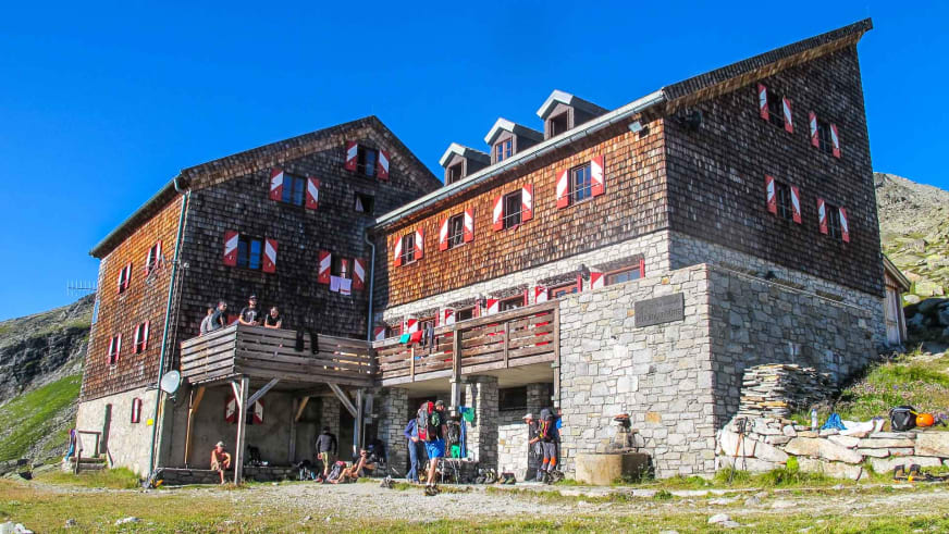 Bergsteiger versammeln sich vor der Kürsinger Hütte bei sonnigem Wetter vor ihrer Tour auf den Großvenediger.