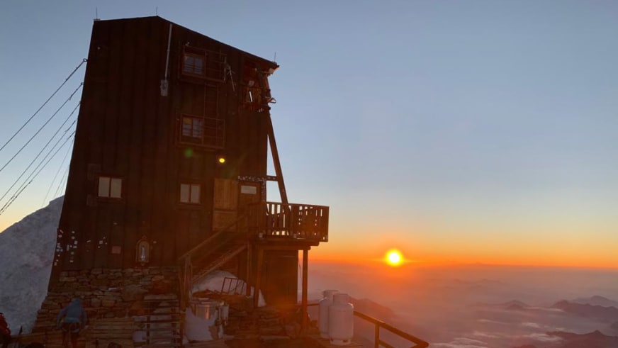 Sonnenuntergang hinter der Capanna Margherita mit warmem Orange-Licht über den Walliser Alpen.