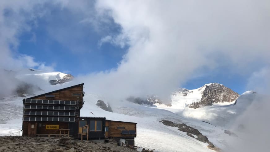 Seitenprofil des Rifugio Quintino Sella al Felik mit Solardach in schneebedeckter Gletscherlandschaft der Walliser Alpen