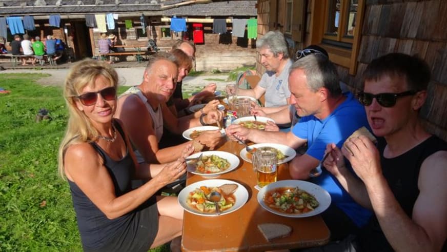 Wanderer nehmen ihr Mittagessen auf der Außenterrasse der Wasseralm im Nationalpark ein.