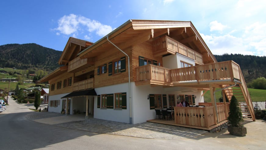 Außenansicht des Alpinhotel Berchtesgaden mit traditioneller Alpenarchitektur und grünen Fensterläden.
