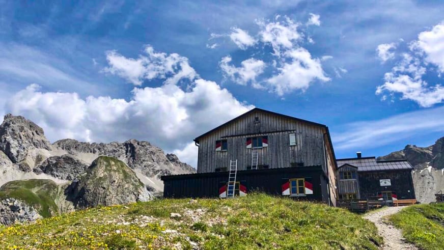 Die Memminger Hütte steht auf einer Anhöhe umgeben von schroffen Felswänden und Geröllhalden.