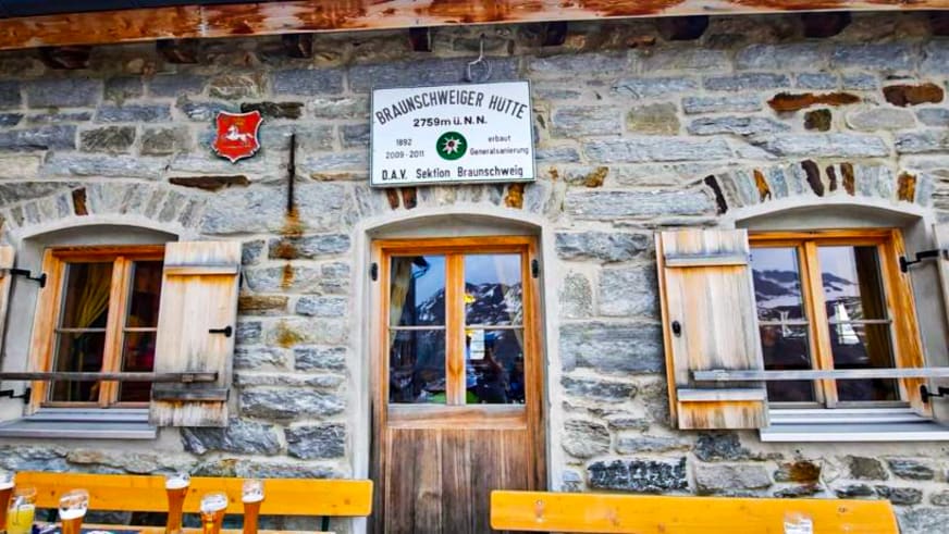 Frontalansicht der Braunschweiger Hütte aus Naturstein mit Hüttenschild und DAV-Logo in den Ötztaler Alpen.