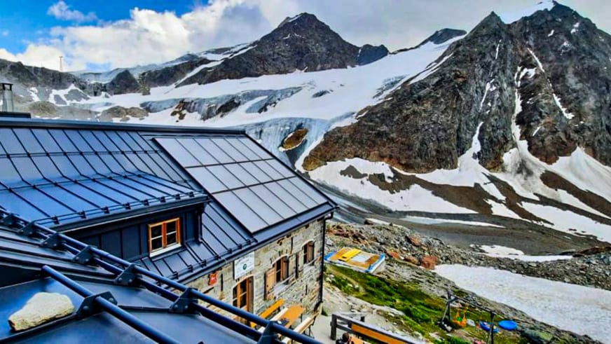 Nächtliche Aufnahme der beleuchteten Braunschweiger Hütte vor schneebedeckten Gipfeln der Hochgebirgslandschaft.