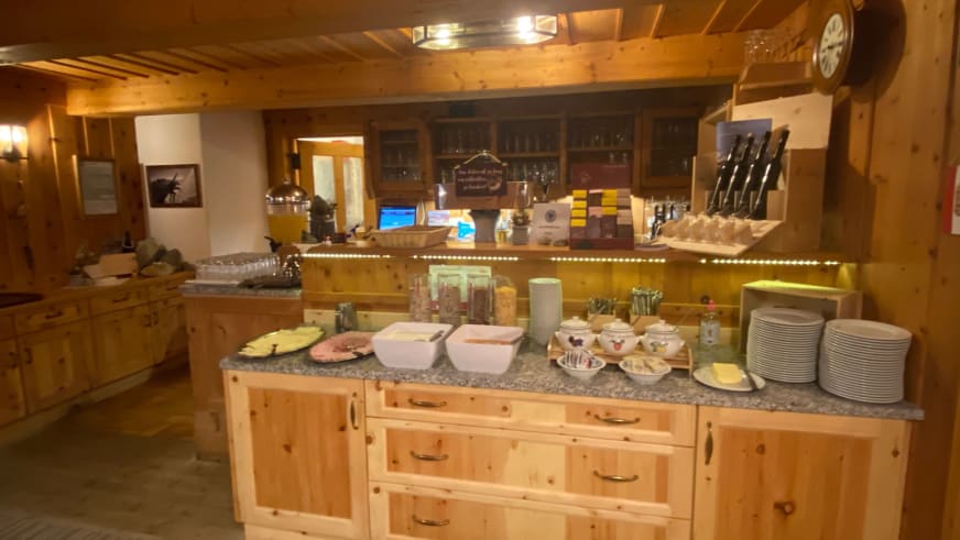 Buffetbereich der Warnsdorfer Hütte mit Aufschnitt und Käse auf heller Holzkücheninsel arrangiert.