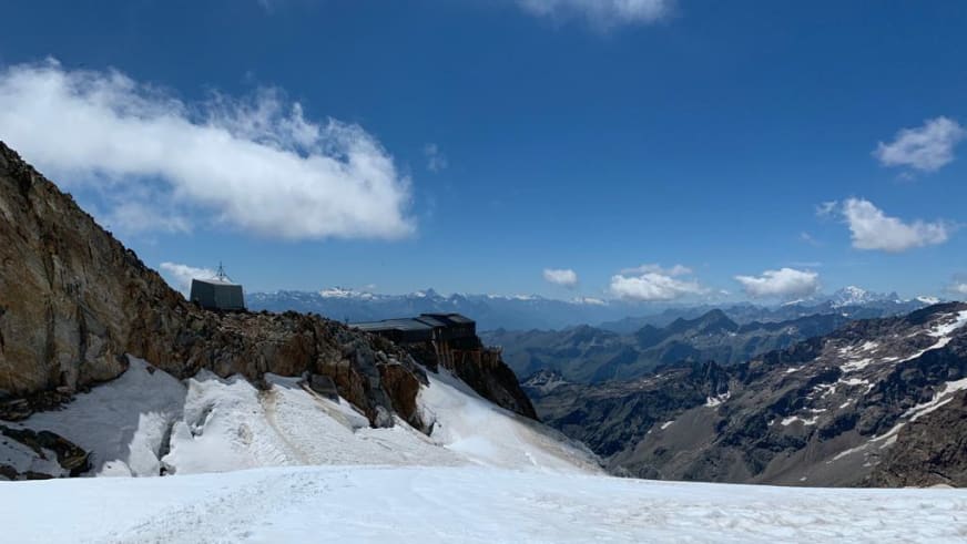 Panorama der Capanna Gnifetti auf schmalem Felsgrat zwischen Firn und Gletscherspalten.