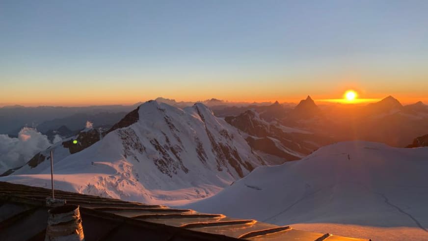 Morgensonne über der Capanna Gnifetti mit verschneiter Gletscherlandschaft der Walliser Alpen.