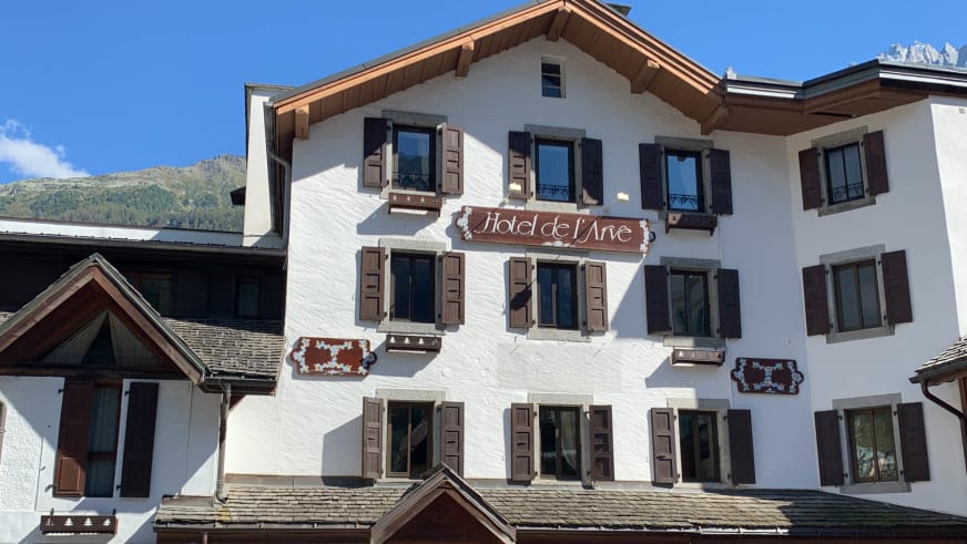 Hauptfassade des Hotel de L'Arve Chamonix mit weißer Fassade und braunen Holzfensterläden.