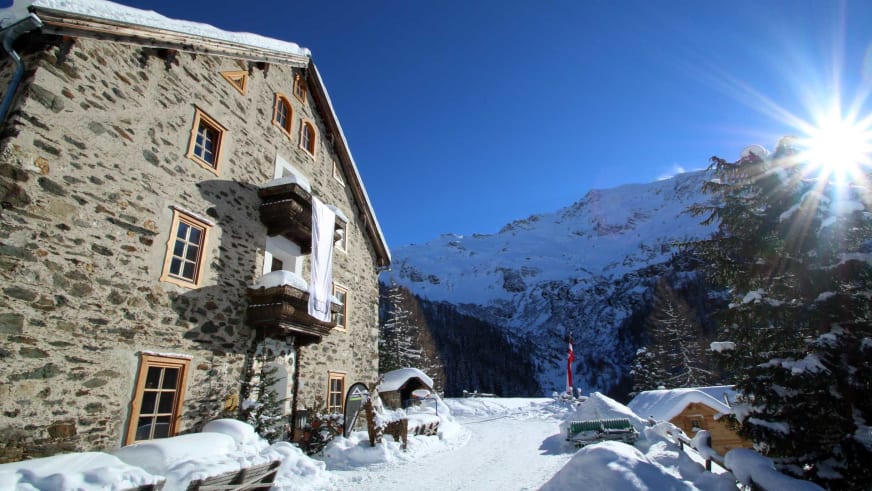 Der Ammererhof in Kolm-Saigurn zeigt sich im Winter als traditionelle Alpenherberge aus Naturstein mit schneebedeckter T