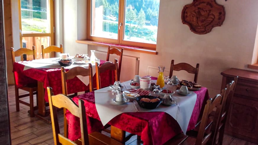Gastraum im Rifugio Col Gallina mit gedeckten Holztischen und traditioneller alpiner Einrichtung.