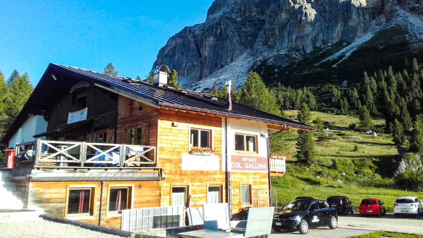 Außenansicht des Rifugio Col Gallina mit typischer alpiner Architektur aus Holz und weißem Putz.