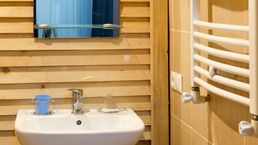 Vollständig holzverkleidetes Badezimmer der Villa Mestia mit rundem Waschbecken und Handtuchheizkörper.