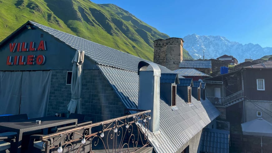 Außenansicht der Villa Lileo mit charakteristischem blauen Gebäude und historischem Steinturm in Ushguli, Swanetien.