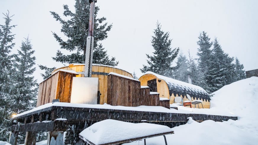 Moderner Spa-Bereich mit Jacuzzi und Sauna neben der Cabana Negoiu in verschneiter Waldlandschaft.