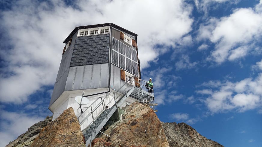 Die Cabane de Bertol steht auf einem schmalen Felsgipfel mit moderner Architektur und Solarpanels.