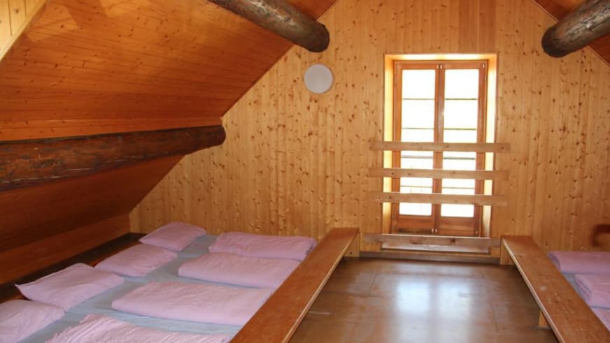 Gemütliches Dachzimmer im Albergo San Gottardo mit sichtbaren Holzbalken und zwei Einzelbetten.