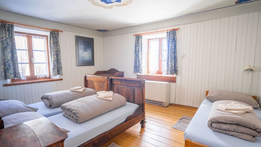 Traditionelles Gästezimmer im Albergo San Gottardo mit zwei Einzelbetten und alpiner Holzausstattung.