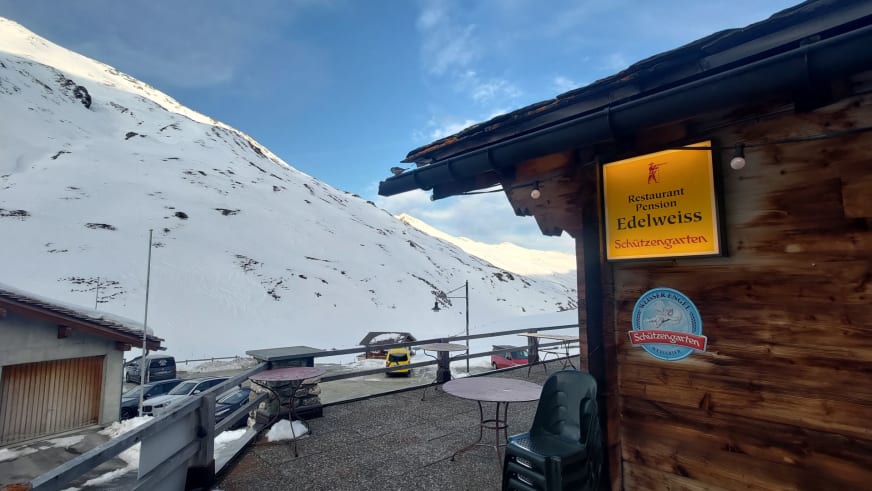 Die Pension Edelweiss Juf mit Holzfassade und Restaurant-Schildern steht verschneit auf 2.126 m Höhe im Averstal.