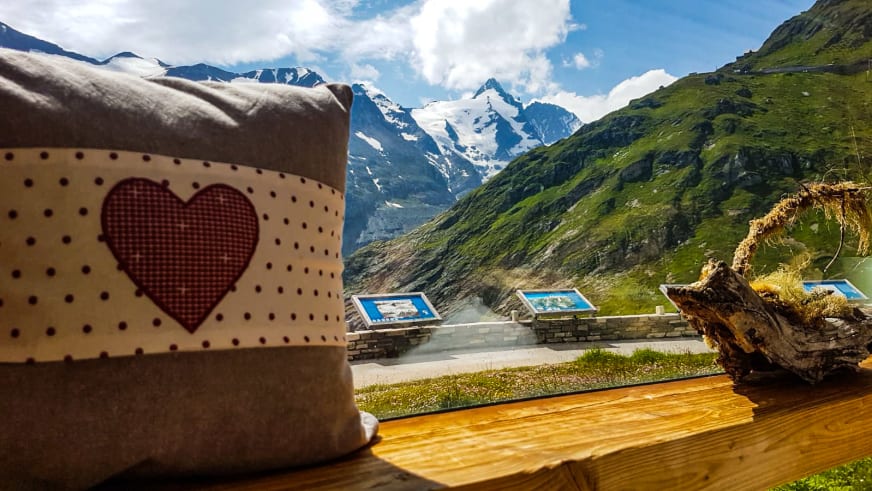 Von der Terrasse des Glocknerhaus eröffnet sich der Blick über grüne Täler zu den schneebedeckten Gipfeln der Hohe Tauern.